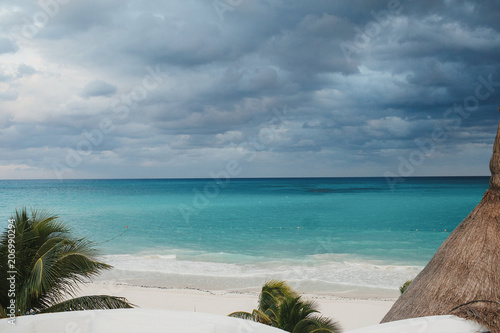 Beautiful view from the white beach at heavy clouds over the sea