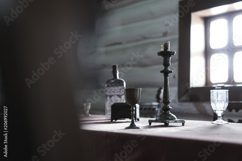 Retro Candelabra With Candles In old Room Interior  wooden house  vintage glass and metal beaker on a table