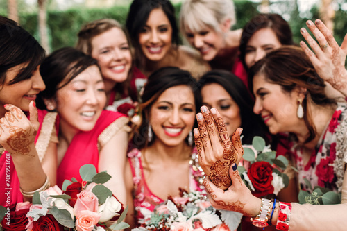 Indian bridesmaids admire beautiful bride posing together in the garden