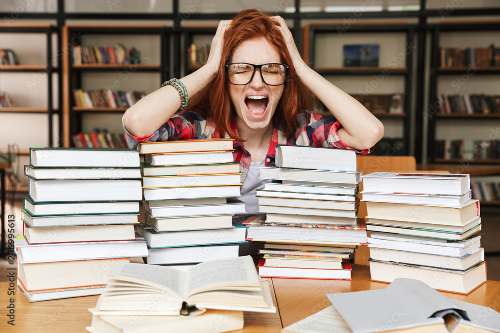 Shocked teenage girl sitting at the library Shocked teenage girl sitting at the library
