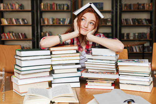 Smiling teenage girl sitting at the library