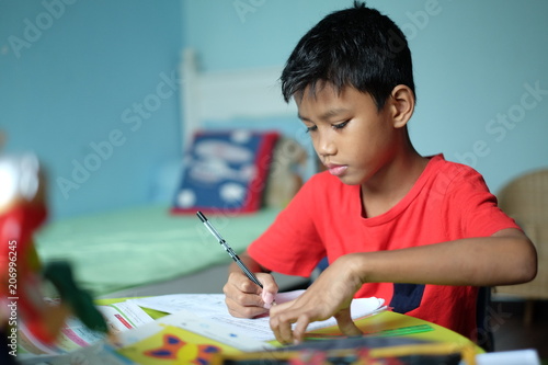A clever boy doing his homework at hos
