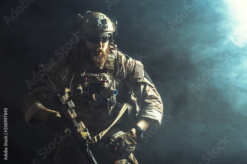 фотографія Special forces soldier with rifle on dark background