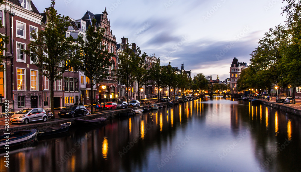Canal in Amsterdam by night with reflections in the water