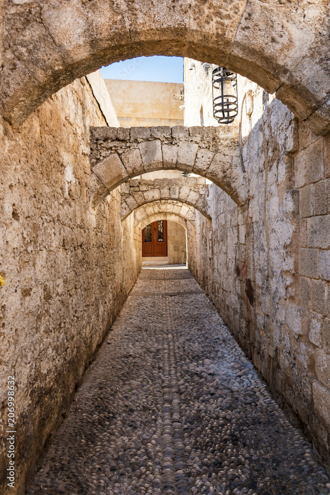 Narrow medieval street of old town in City of Rhodes (Rhodes, Greece)