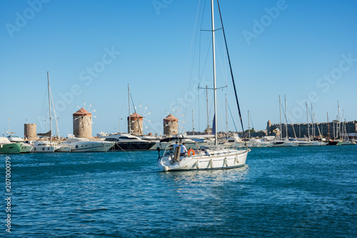 Boats  yachts and windmills in Mandraki harbor in City of Rhodes  Rhodes  Greece 