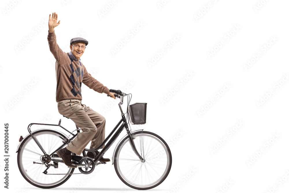 Naklejka premium Cheerful senior riding a bicycle and waving at the camera