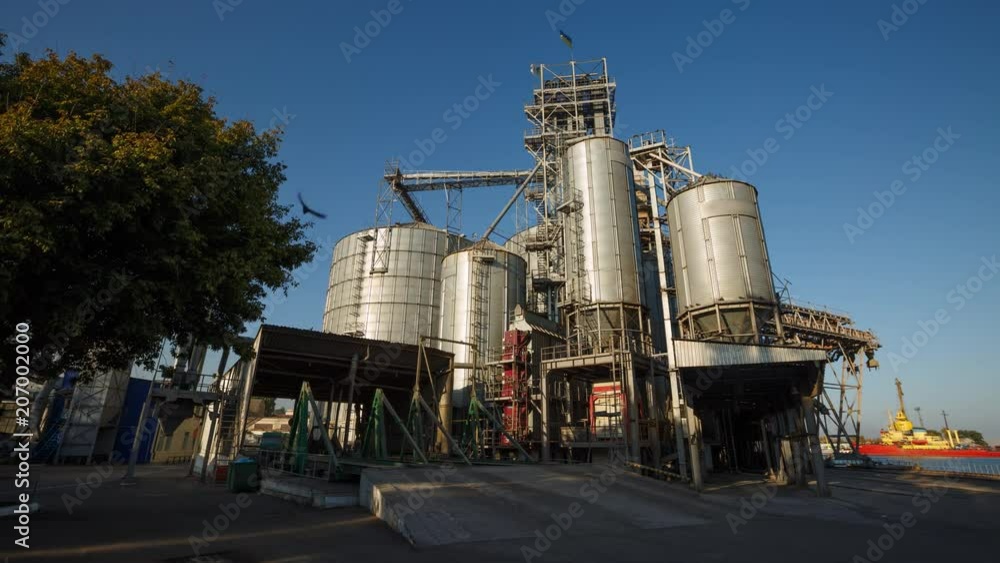 Timelapse of unloading grain trucks at elevator on elevating hydraulic platform unloader. Grain crops transshipment at big sea terminal at seaport. Fast logictics concept. Timelapse of unloading grain trucks at elevator on elevating hydraulic platform unloader. Grain crops transshipment at big sea terminal at seaport. Fast logictics concept.