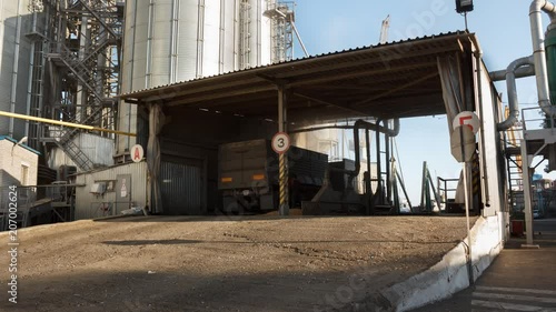 Timelapse of unloading grain trucks at elevator on elevating hydraulic platform unloader. Grain crops transshipment at big sea terminal at seaport. Fast logictics concept. photo