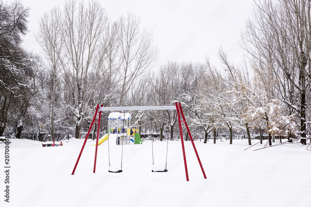 snowy park with swings and trees, empty on a cold winter day
snowy park with swings and trees, empty on a cold winter day