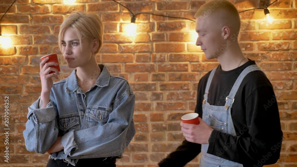 Young beautiful girl hipster is standing with cup, her boyfriend is coming, they throw out cups, French kiss, passion conception