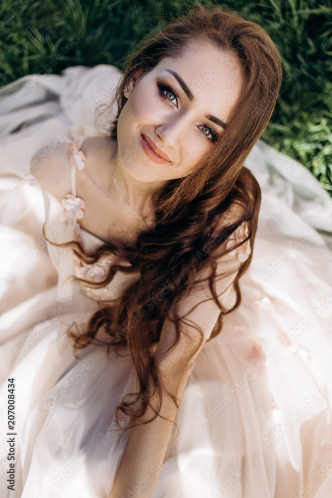 The charming bride sitting on the grass The charming bride sitting on the grass