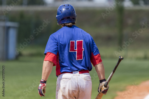 Baseball player holding baseball bat in hand