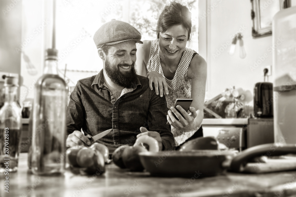 couple sharing a good time while preparing lunch in the kitchen couple sharing a good time while preparing lunch in the kitchen