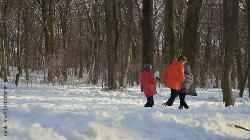 Three brothers play snowballs in winter park, slow motion photo