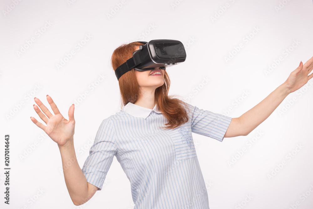 Happy young red-haired woman using a virtual reality headset Happy young red-haired woman using a virtual reality headset