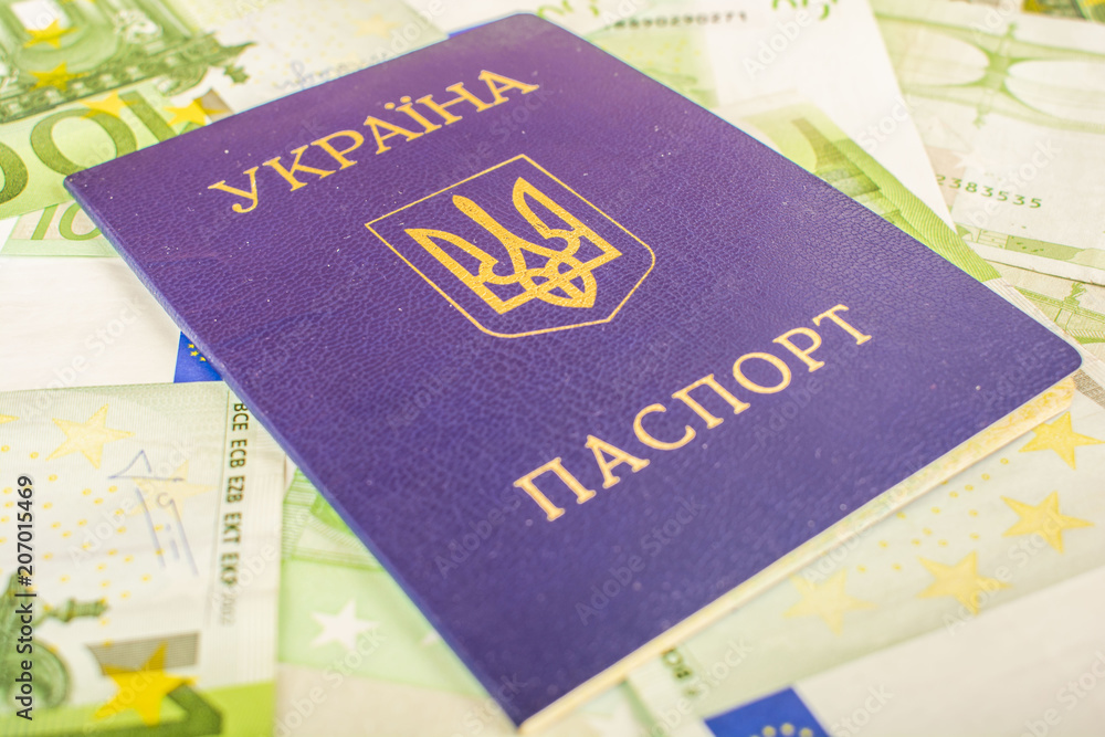 Ukrainian passport against the background of Euro-accounts with a face value of 100 Ukrainian passport against the background of Euro-accounts with a face value of 100