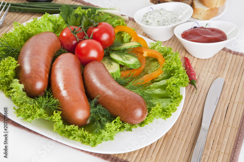 Boiled sausages with tomatoes, cucumbers and greens. Served with black or white bread.