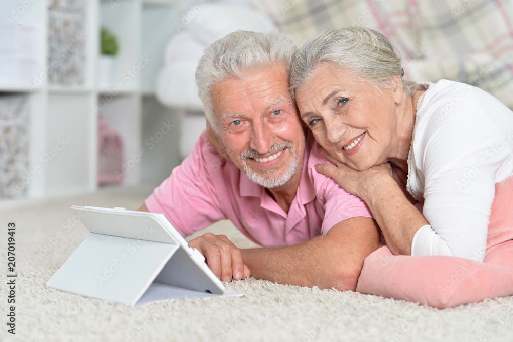 happy senior couple using tablet