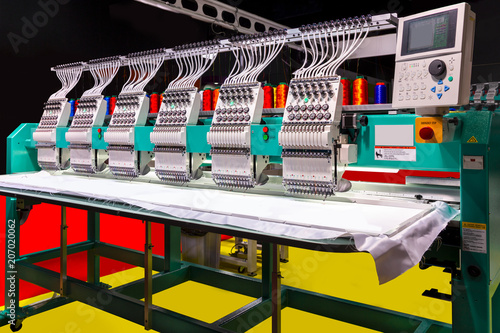 Textile - Professional and industrial embroidery machine. Machine embroidery is an embroidery process whereby a sewing machine or embroidery machine is used to create patterns on textiles. photo