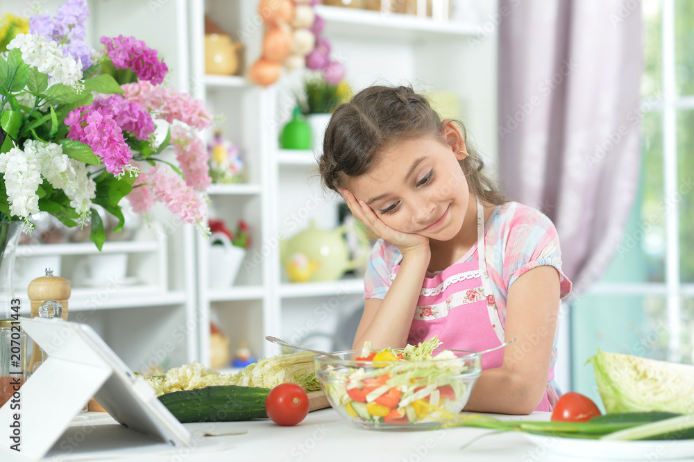 Cute little girl making dinner