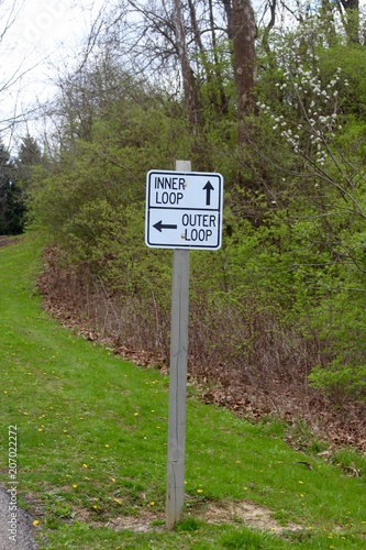The black and white park trail sign on a close view.