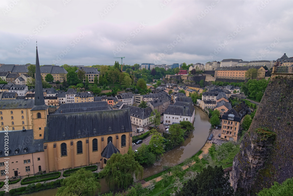 Beautiful skyline of old town Luxembourg City from top view in Luxembourg. Abbaye St. John Neimenster near Alzette River at spring cloudy day. Luxembourg, Grand Duchy of Luxembourg