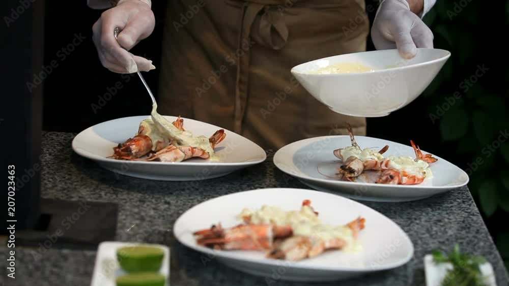 Chef serves shrimp with sauce Chef serves shrimp with sauce