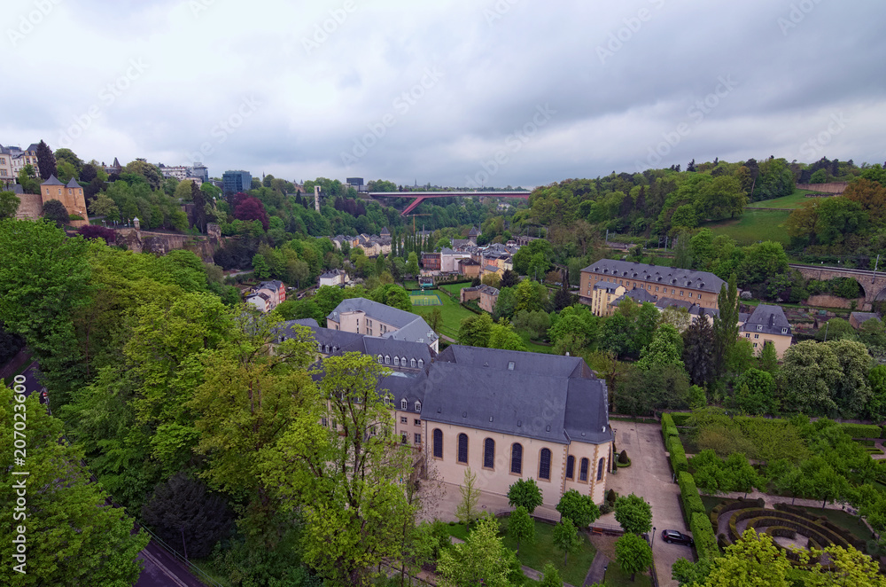 Awesome landscape view of old town Luxembourg City from top view. Grand Duchess Charlotte Bridge at the background. Spring cloudy day. Luxembourg, Grand Duchy of Luxembourg