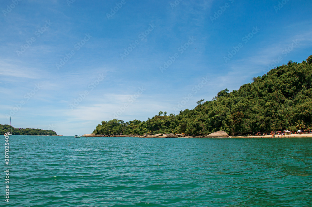 Fototapeta premium View of beach, sea and forest on sunny day in Ilha do Pelado, a tropical beach near Paraty, an amazing and historic town totally preserved in the Rio de Janeiro State, southwestern Brazil