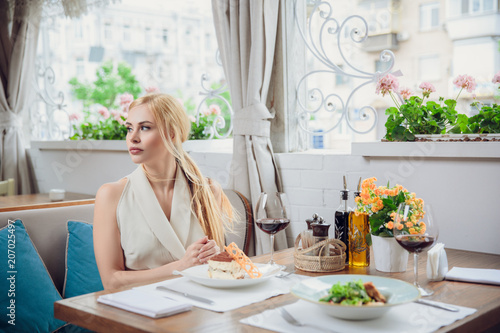 young woman waiting someone who late, and looking for her boyfriend in coffee shop. Portrait of young unhappy stressed beautiful female sitting in modern urban cafe.