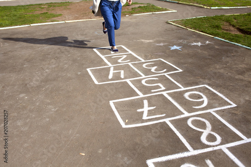 An adult girl passed by the hopscotch and decided to jump