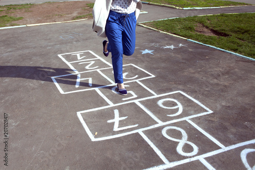 An adult girl passed by the hopscotch and decided to jump photo