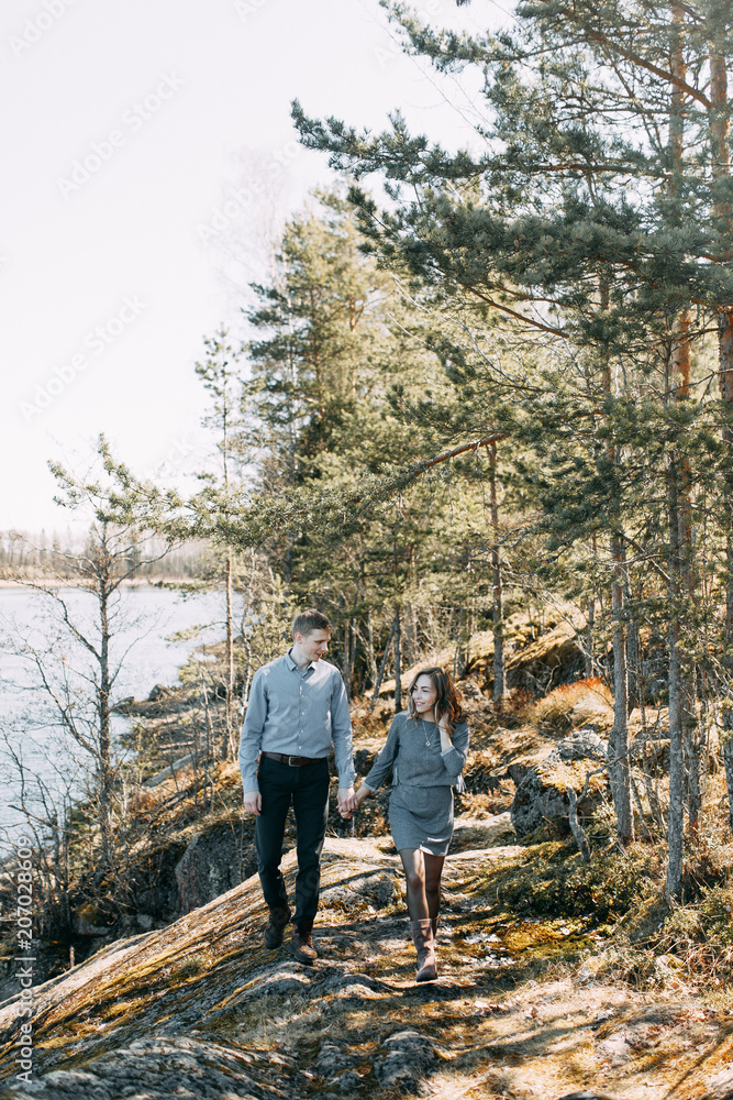 Pre-wedding photo shoot in the forest in nature, in the form of walking and traveling. Beauty of the North and Russia. Loving people and beautiful scenery. They laugh, sit and smile. Beautiful couple Pre-wedding photo shoot in the forest in nature, in the form of walking and traveling. Beauty of the North and Russia. Loving people and beautiful scenery. They laugh, sit and smile. Beautiful couple