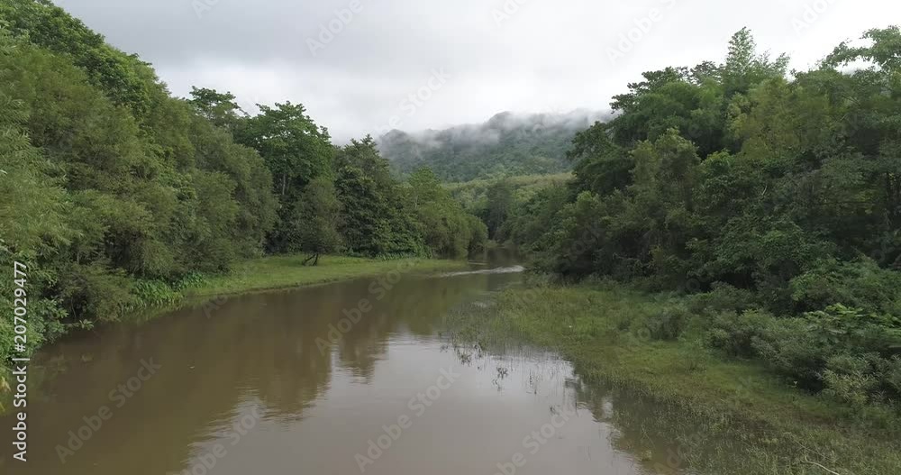 Beautiful natural scenery of river in Asia tropical green forest with mountains in background, aerial view drone shot - video in slow motion Beautiful natural scenery of river in Asia tropical green forest with mountains in background, aerial view drone shot - video in slow motion