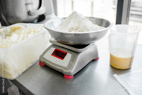 Weighing flour for baking with professional scales at the manufacturing, close-up view