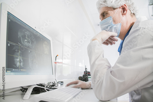 Dr. dentist works in front of the monitor in the medical office
 photo