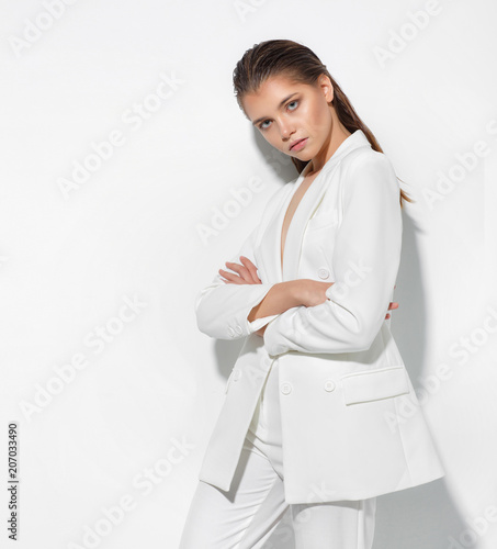 Young woman on a white wall background. High fashion