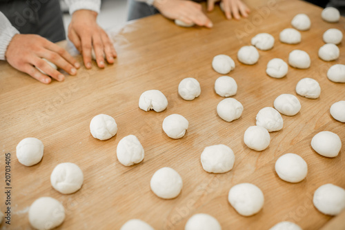Forming daugh balls for baking buns on the wooden table at the manufacturing