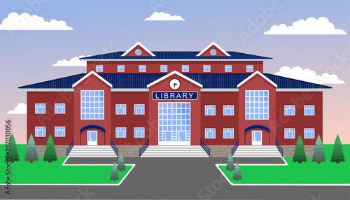 library, classic brick two-storey building of red brick and with a blue tiled roof, with three entrances and a clock in the center, against the blue sky, with lawn, paths, firs