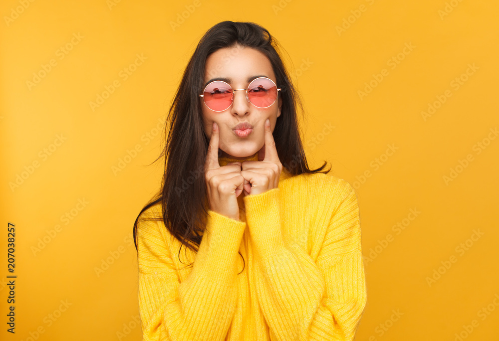 Woman in sunglasses touching cheeks Woman in sunglasses touching cheeks