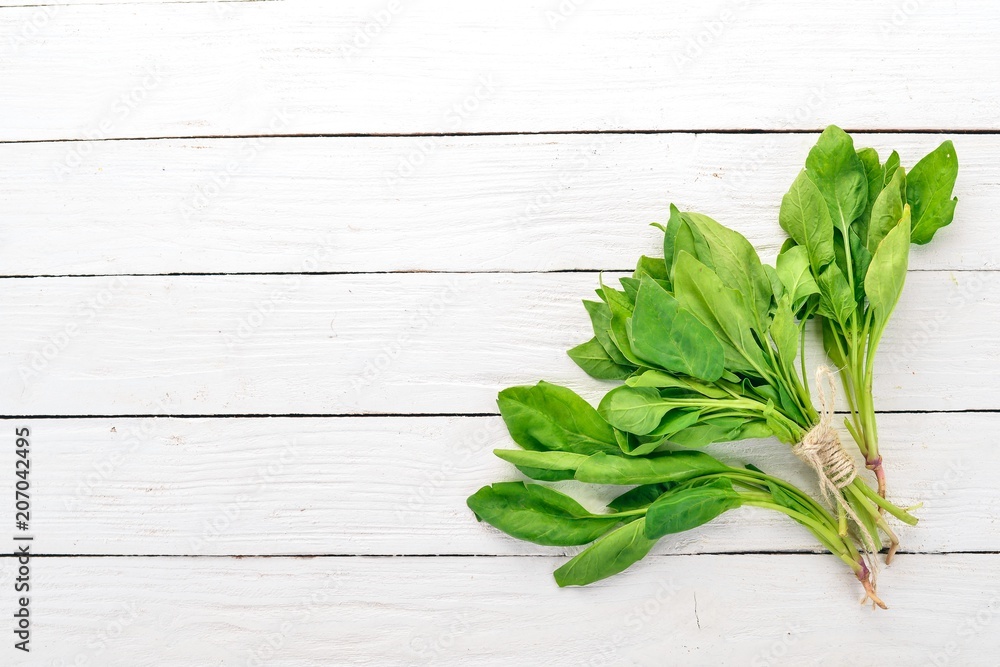 Green Fresh Spinach. On a wooden background. Healthy food. Top view. Copy space.
