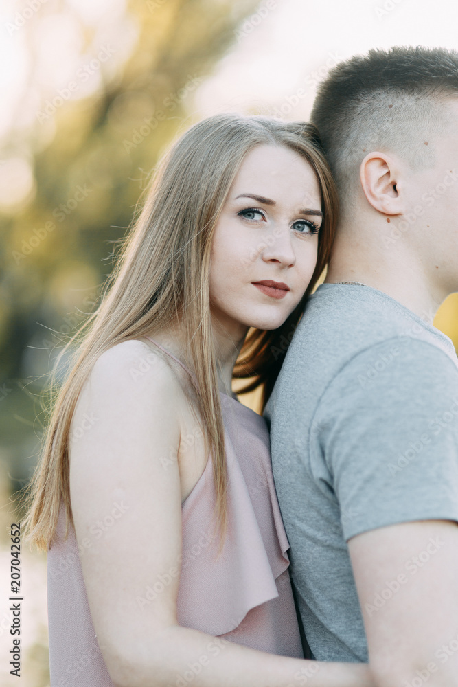 Beautiful young couple in the Park on a Sunny day, loving and happy. Walk and laugh. Pre-wedding shooting in nature. Casual style in clothing and European in processing Beautiful young couple in the Park on a Sunny day, loving and happy. Walk and laugh. Pre-wedding shooting in nature. Casual style in clothing and European in processing
