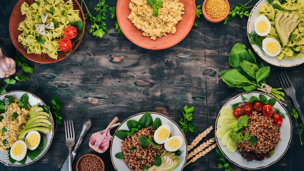 A set of food from buckwheat, bulgur and pasta. On a wooden background. Top view. Copy space. A set of food from buckwheat, bulgur and pasta. On a wooden background. Top view. Copy space.