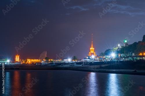 Sochi, Russia - May 23, 2018: Quay of the city of Sochi, at night, overlooking the sea port and lighthouse