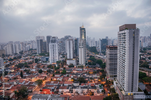 View of the city skyline in the early morning light with houses and buildings under cloudy skies in the city of São Paulo. The gigantic city, famous for its cultural and business vocation. © Celli07