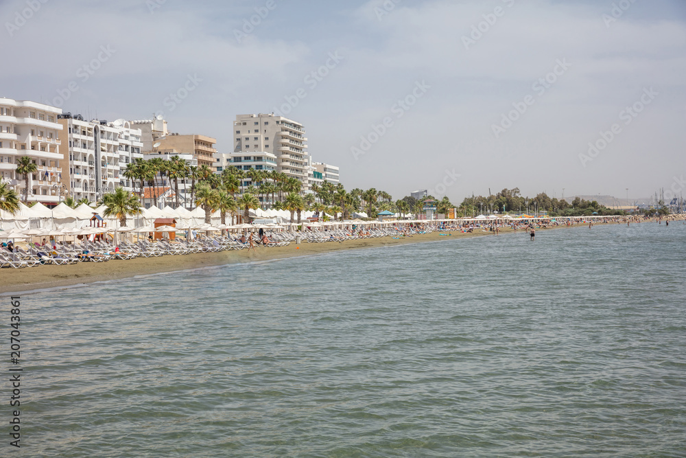 Cyprus, Larnaca. Multi-storey buildings, sandy beach, blue sea and sky