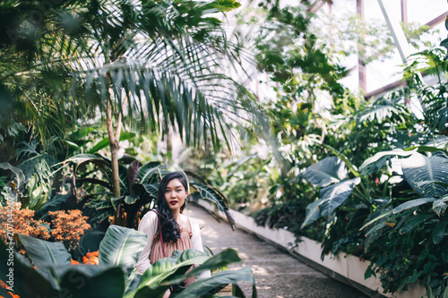 Photo Session of a beautiful young girl in blooming magnolia, cactus and other vegetation. © dimadasha
