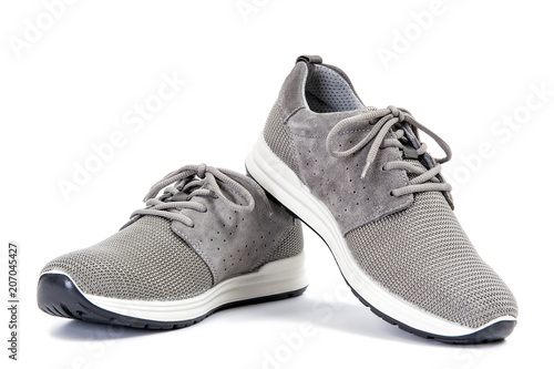 Close-up of elegant gray sport shoes for adult man photographed on white background.