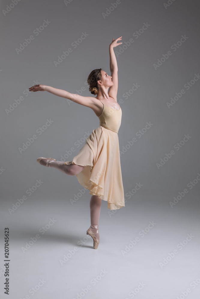 A kind of magic! Young attractive tender graceful ballerina with a perfect body dancing in the modern studio on the isolated background.